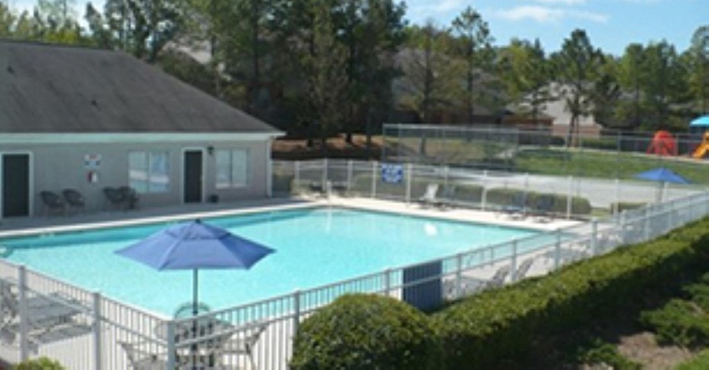 a resort style swimming pool in front of a house