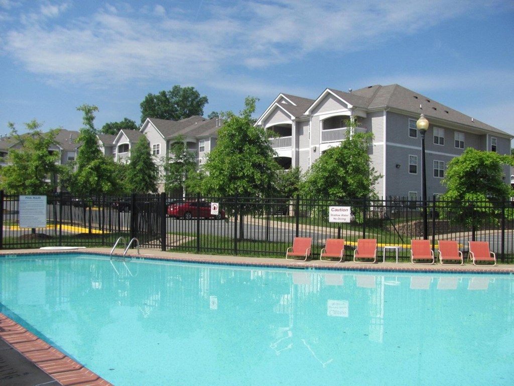 a swimming pool with apartment buildings in the background at Woodwind Villa, Woodbridge, VA 22191