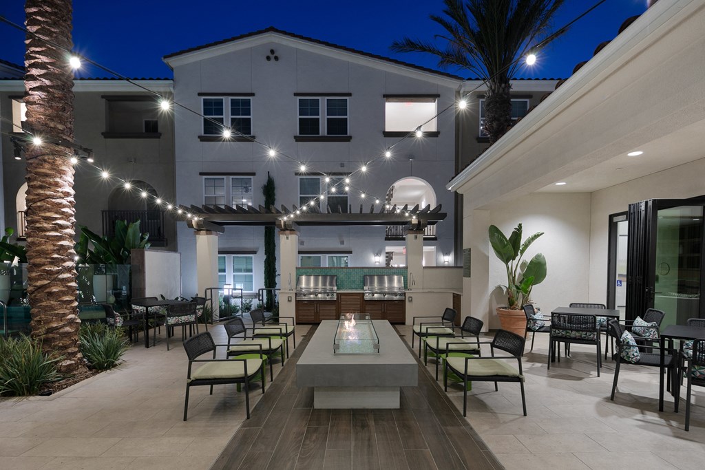 a large patio with tables and chairs and a building in the background