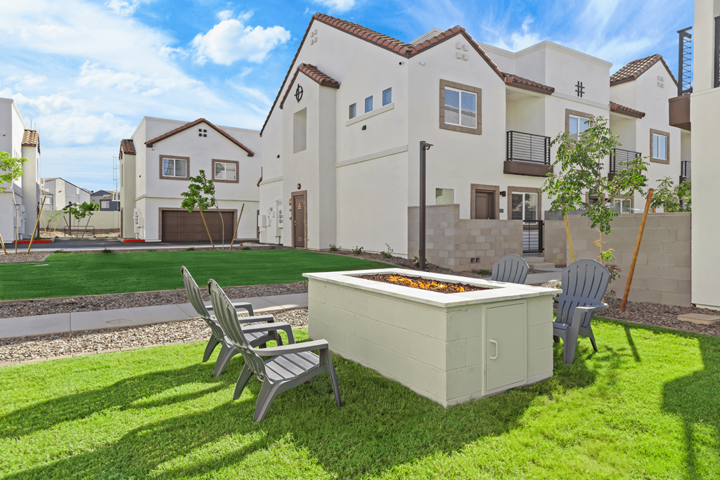 a yard with a hot tub and chairs in front of a house