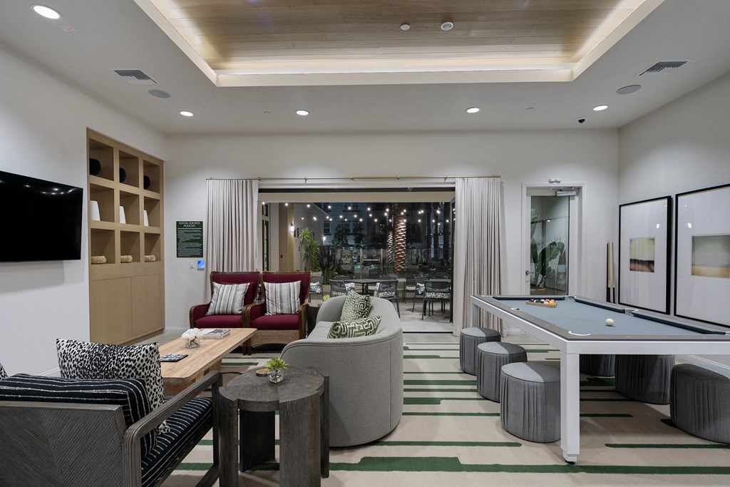 a lobby with couches and tables and a pool table