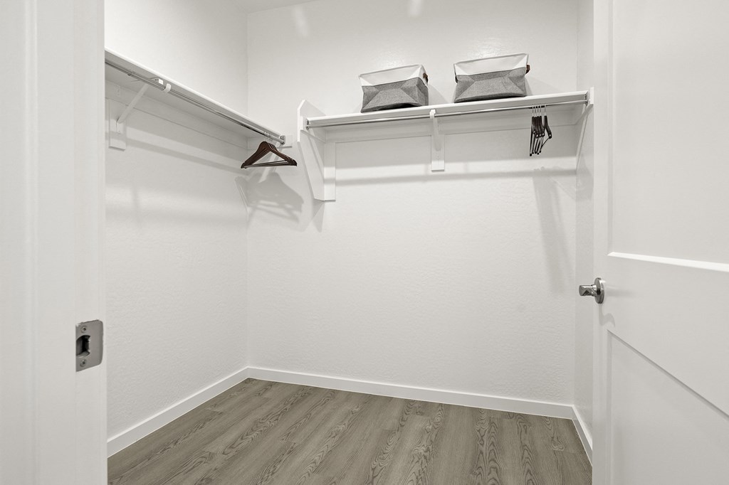 an empty closet with a white wall and a white door