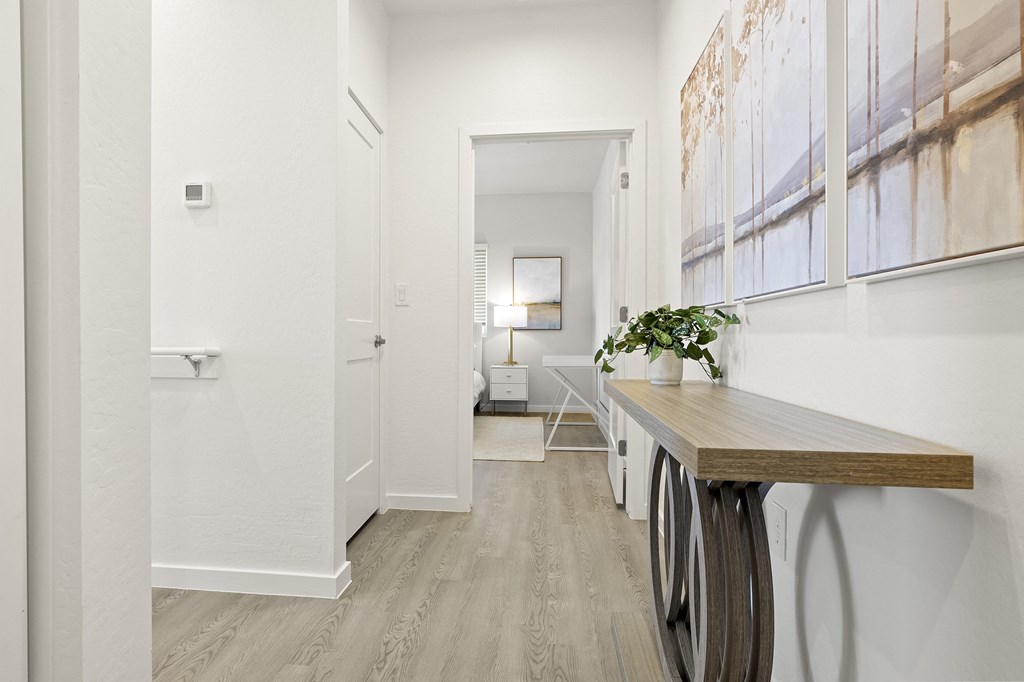 a hallway with a desk and a door to a bathroom