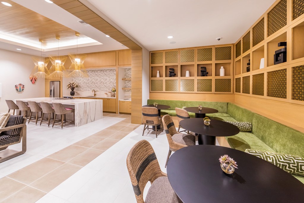 the lobby of a hotel with tables and chairs and a bar