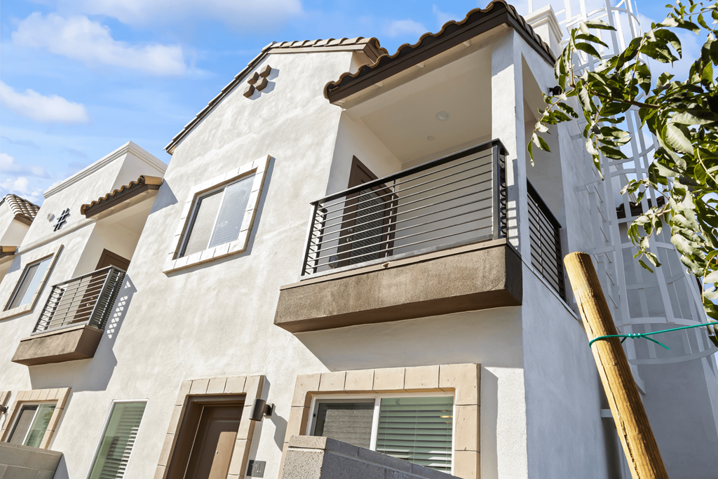 a white building with a balcony and a blue sky