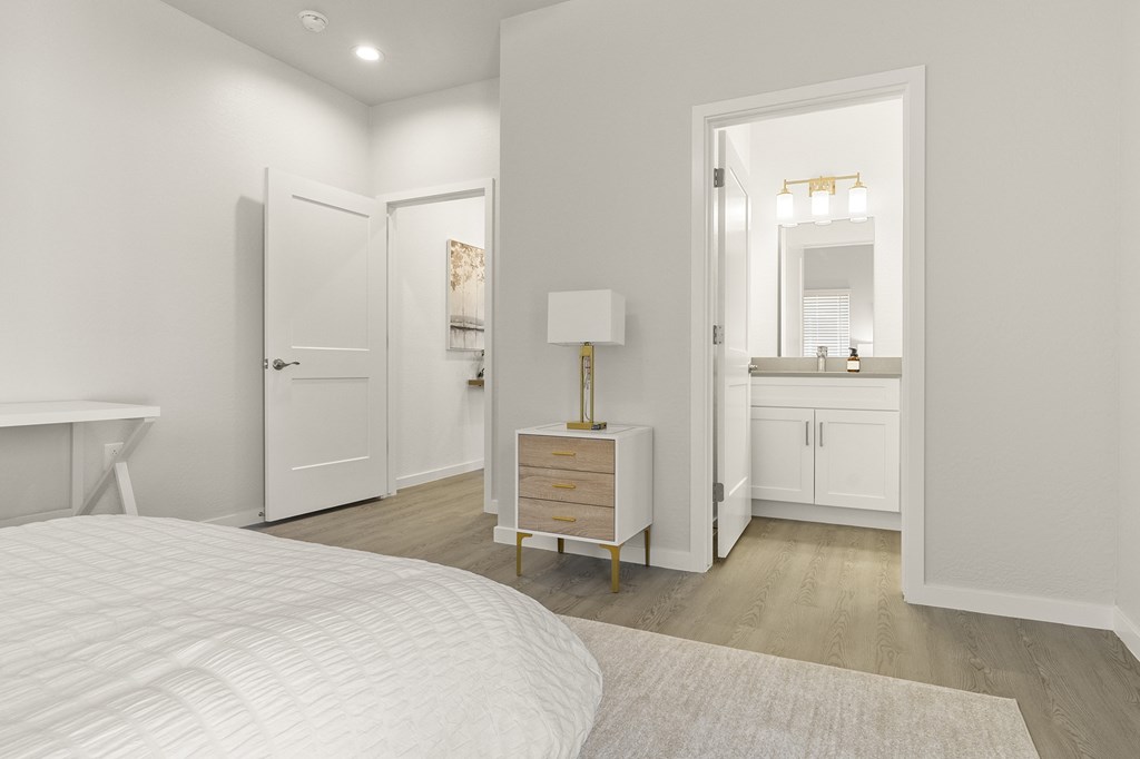 a bedroom with a bed and a bathroom with a sink