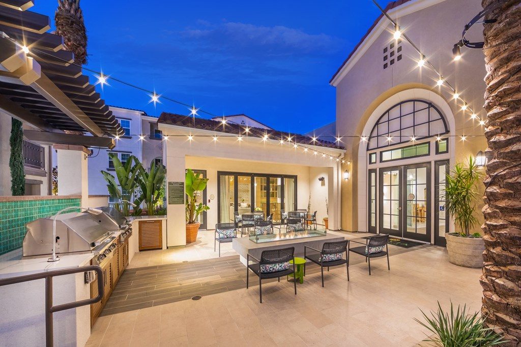 a patio with a grill and a table and chairs
