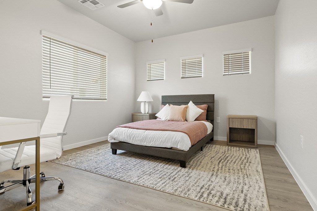 a bedroom with a bed and a desk with a chair