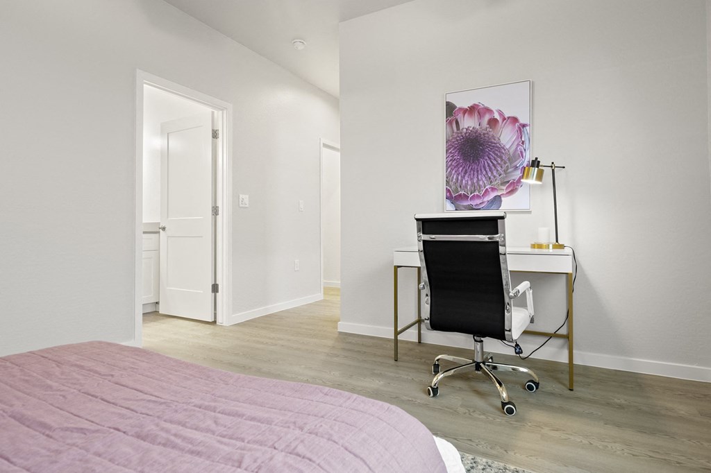 a bedroom with a bed and a desk with a chair