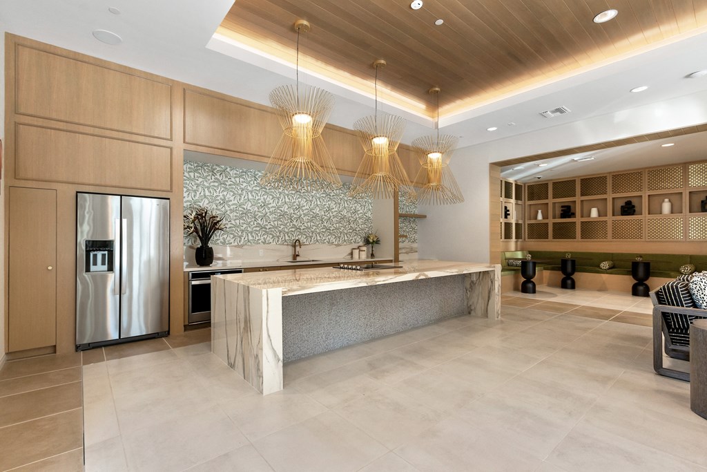 a large kitchen with a marble counter top and a refrigerator