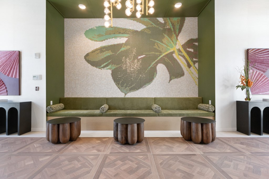 a lobby with a green couch and some stools