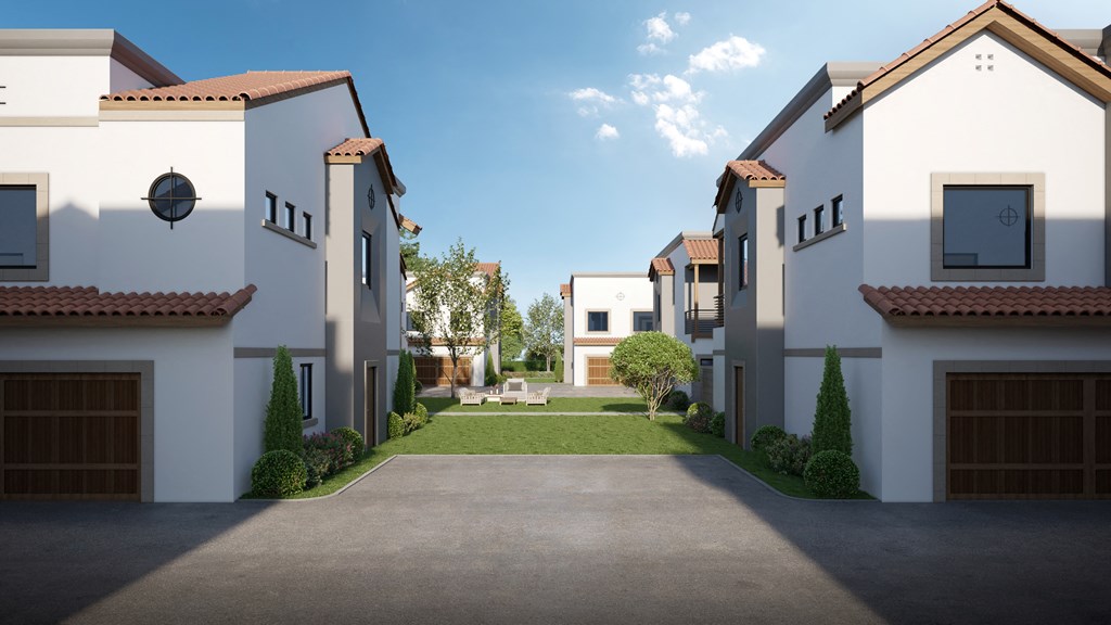 a street view of a row of townhomes with a courtyard and grass