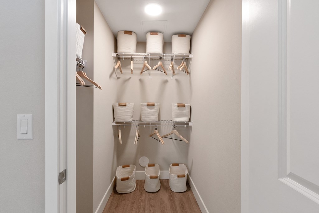 a walk in closet with shelves and hats and shoes