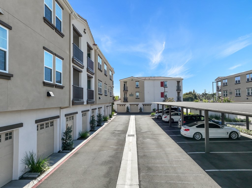 an empty parking lot with several apartment buildings and cars
