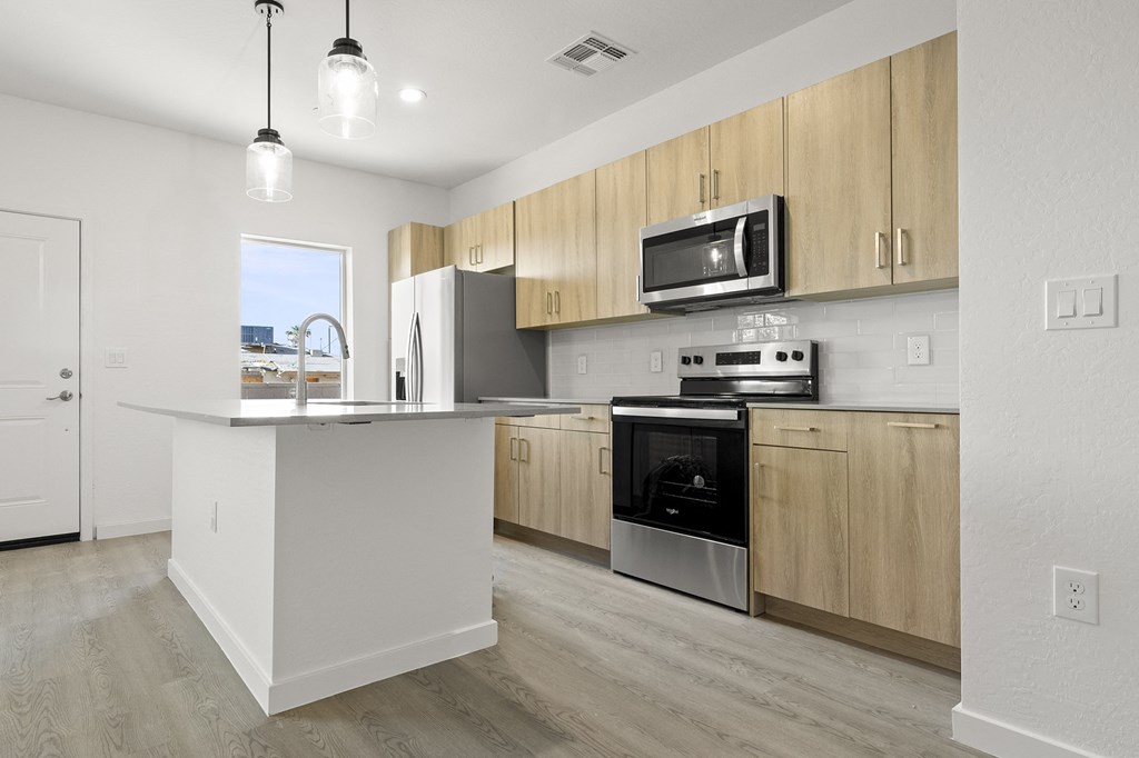 an empty kitchen with wooden cabinets and stainless steel appliances