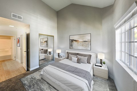 a bedroom with a bed and a large window