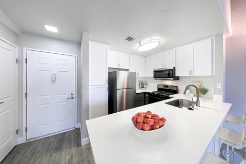a kitchen with a white counter top and a stainless steel refrigerator