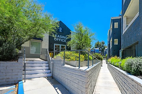 the entrance to leasing office building with stairs and trees