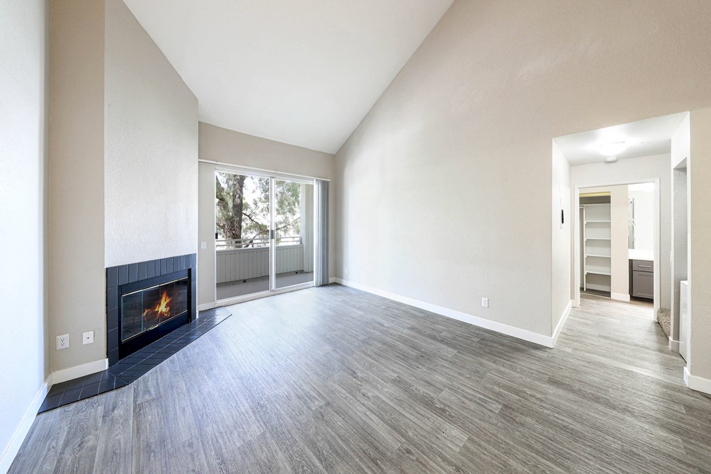 the living room and dining room of a new home with a fireplace