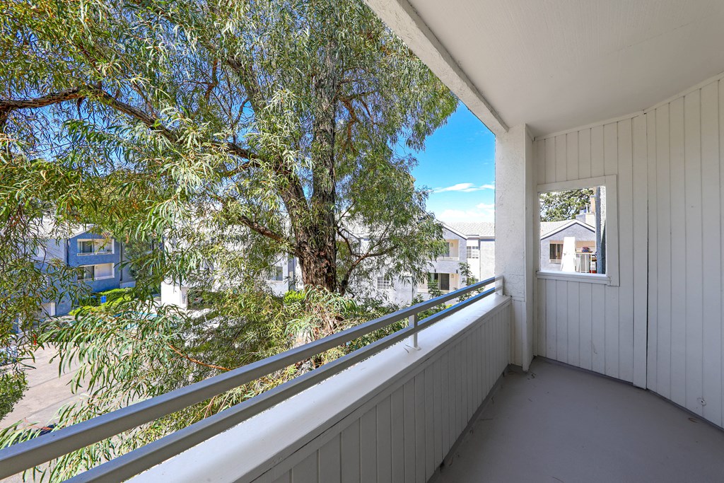 a balcony with a view of a tree and houses