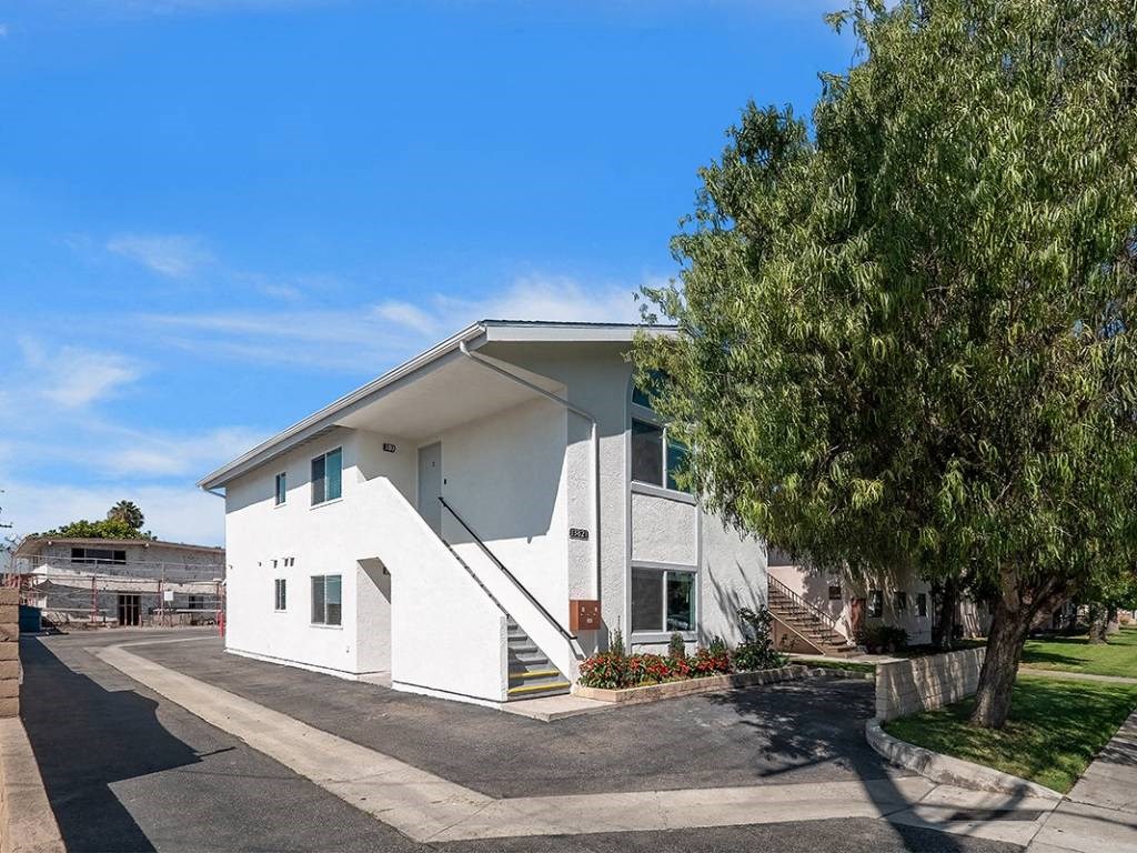a white building with a tree in front of it