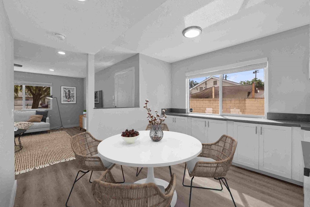 a dining room with a white table and chairs and a large window