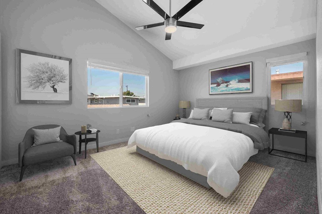 a bedroom with gray walls and a white bed