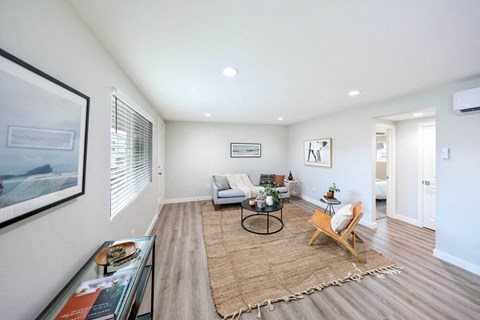 a living room with white walls and hardwood floors