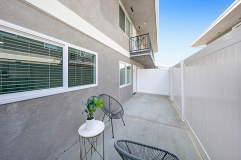 a patio with two chairs and a small table