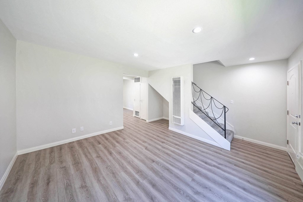 a bedroom with hardwood floors and white walls