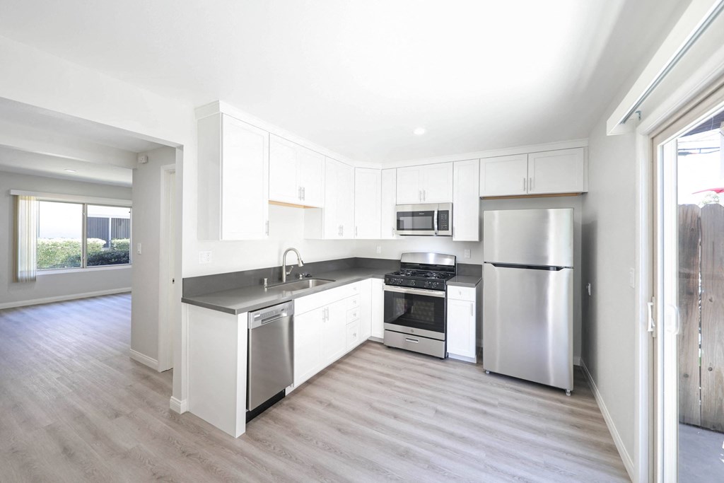 a kitchen with white cabinets and stainless steel appliances