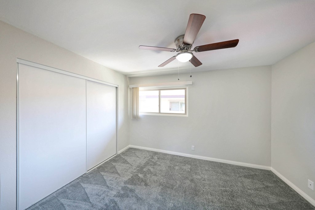 a bedroom with a ceiling fan and closet