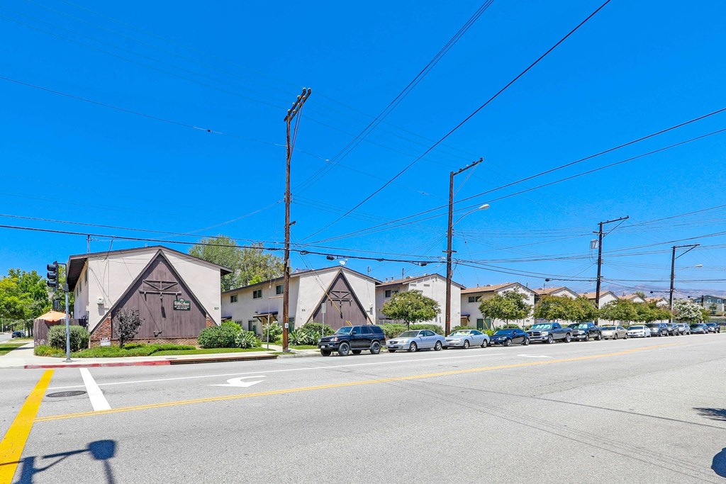 a street with houses and cars parked on the side of the road
