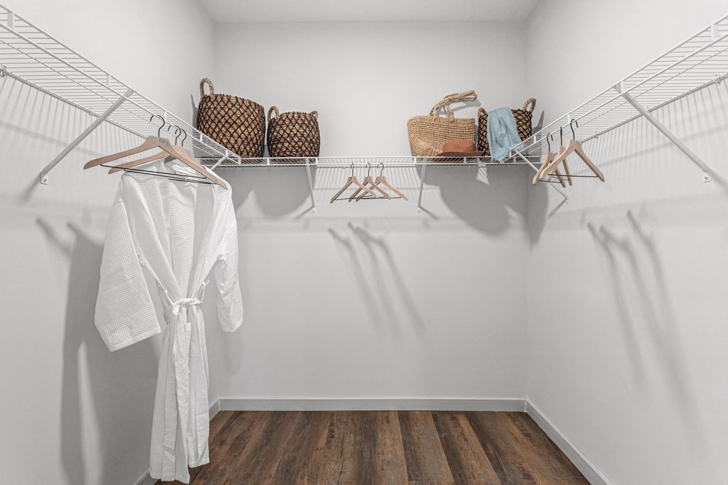 a closet with white walls and a white robe and baskets on the shelves at Casa Marti, Tampa, 33605