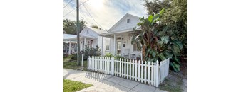 A white picket fence in front of a house.