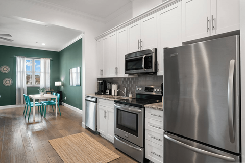 A modern kitchen with a large refrigerator and stainless steel appliances.