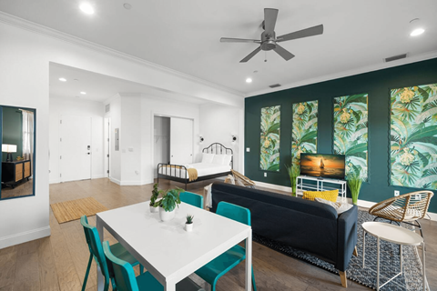 a living room with a couch and a table and a ceiling fan