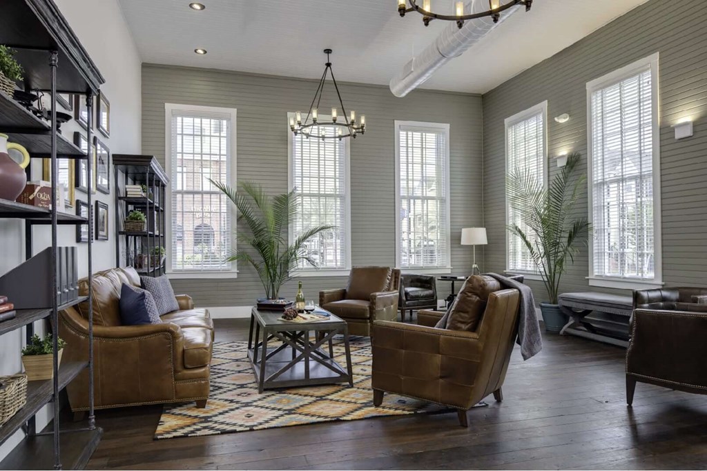 a living room with brown leather furniture and a chandelier