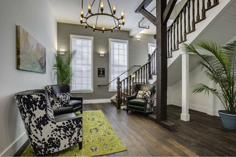 a living room with two chairs and a staircase