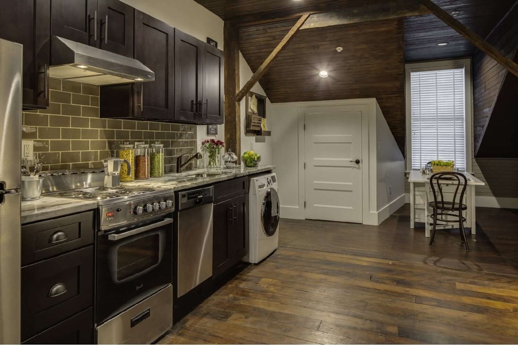 a kitchen with stainless steel appliances and a door to a dining room