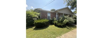 A house with a green lawn in front.