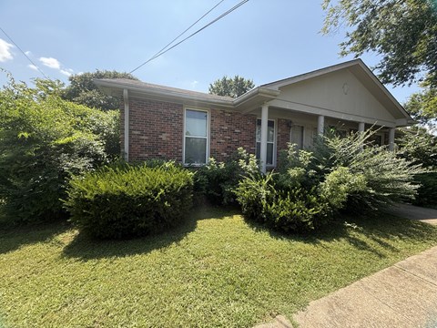 A house with a green lawn in front.