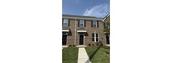 A brick house with a black front door and windows.