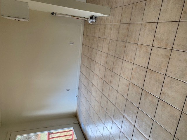 a bathroom with a shower and a tiled wall at Hurd & Bone Property Management, Lebanon, TN