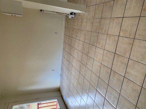 a bathroom with a shower and a tiled wall at Hurd & Bone Property Management, Lebanon, TN
