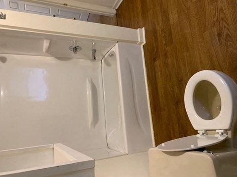 a white bathroom with wood style flooring at Hurd & Bone Property Management, Lebanon, Tennessee