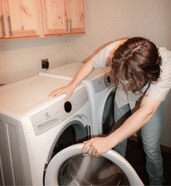 a woman is putting her hand into a washing machine at Campus Park, Minnesota