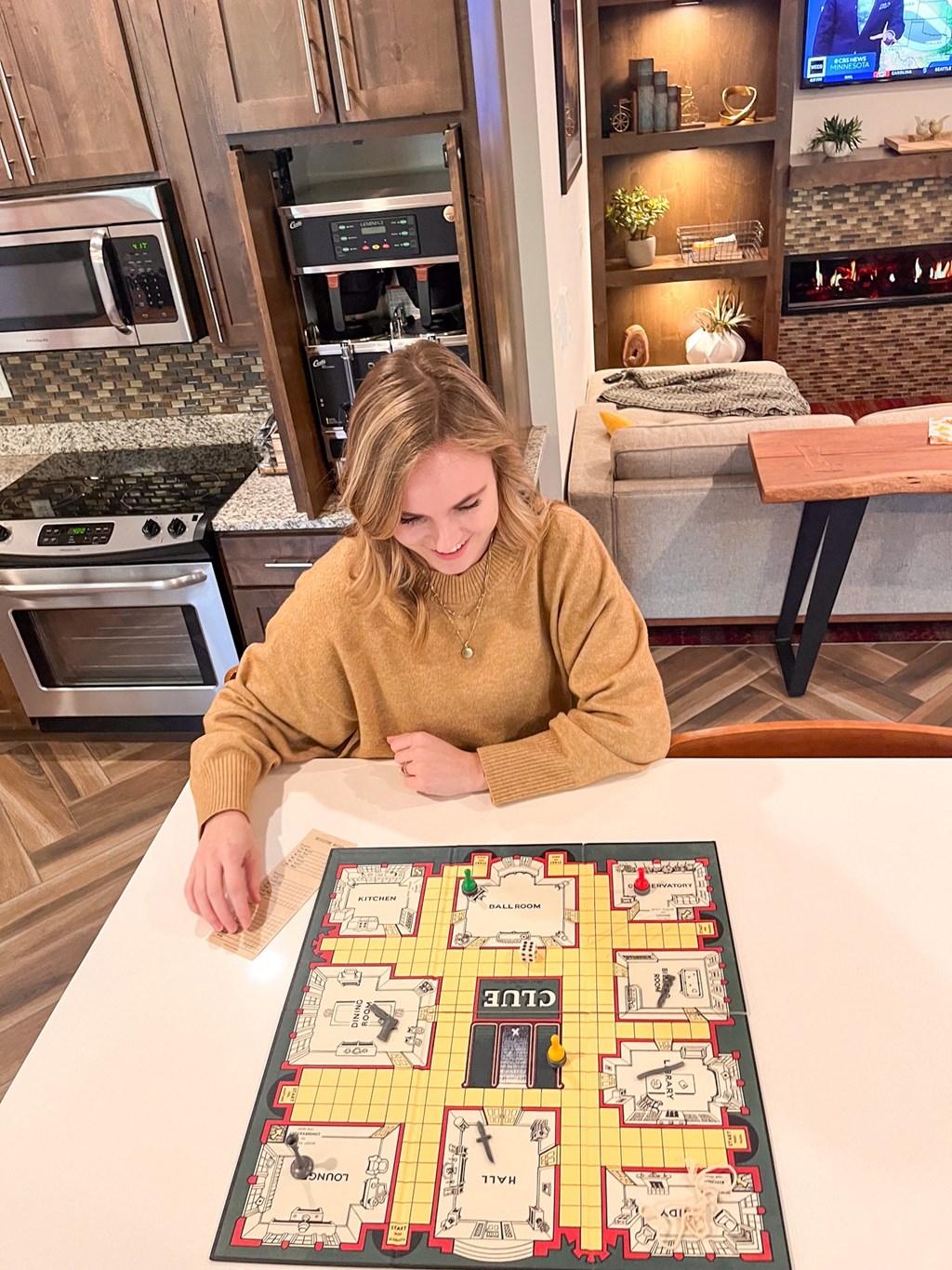 A woman is playing a board game in a kitchen.