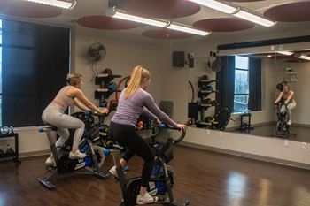 two women on exercise bikes in a gym at Bluestone Lofts, Minnesota, 55803