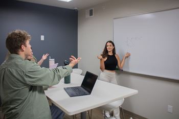 a man and a woman in front of a whiteboard with a laptop at Bluestone Lofts, Minnesota, 55803